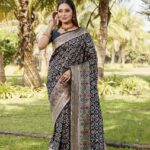 Woman wearing a Gharchola Bandhej silk saree with Paithani pallu and zari border
