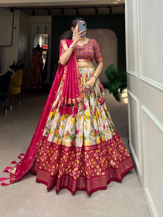 Woman wearing a vibrant Traditional Bandhani Chaniya Choli set with a rani pink blouse, floral lehenga, and matching dupatta from Pramukhmart.