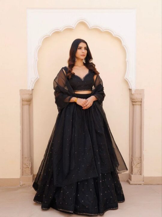 Full-stitched black lehenga with subtle gold sequin hem – flat lay